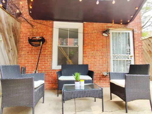 a patio with chairs and a table and a brick wall at Charming 1BDR In Central Rittenhouse Square With Patio Hosted by StayRafa in Philadelphia