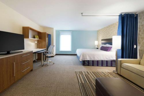 a hotel room with a bed and a desk at Home2 Suites by Hilton Milwaukee Airport in Milwaukee