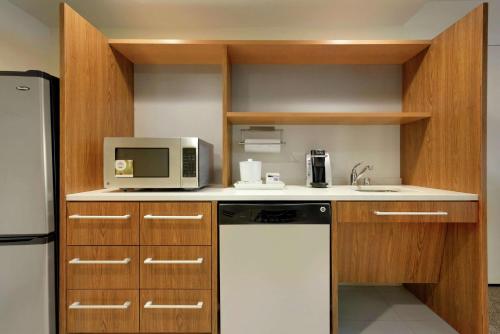 a kitchen with a white refrigerator and a microwave at Home2 Suites by Hilton Milwaukee Airport in Milwaukee