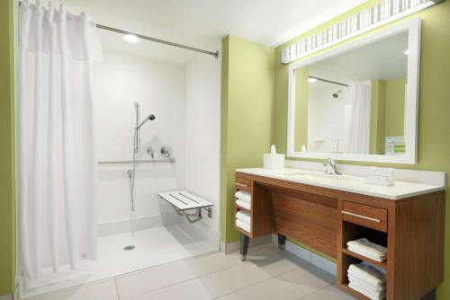 Home2 Suites by Hilton Milwaukee Airport في ميلووكي: حمام مع حوض ودش