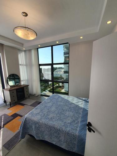a bedroom with a bed and a large window at Dreamy luxury duplex villa with a special view and 300 meters of private garden in Alanya