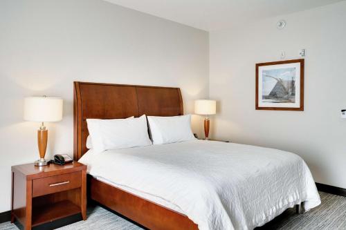 una camera d'albergo con un letto e due lampade di Hilton Garden Inn Milwaukee Airport a Milwaukee