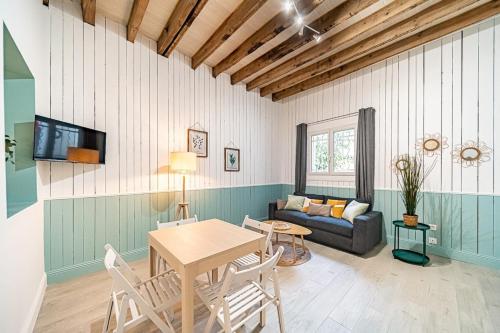 een woonkamer met een tafel en een bank bij La Maison Charpennes-appartement Eucalyptus 4 pers in Villeurbanne
