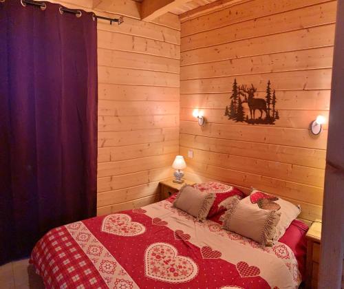 een slaapkamer met een bed in een houten kamer bij Oreeduloup Chalet Japp'loup 10/12 Pers. in Le Dévoluy