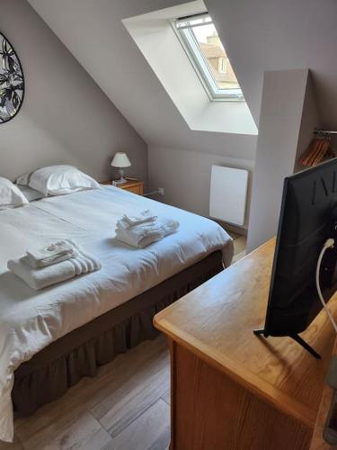 a bedroom with a bed and a desk with a television at Chez Pascale in Le Molay-Littry