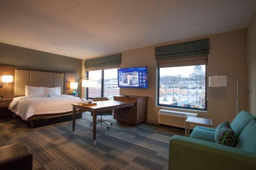 Habitación de hotel con cama, escritorio y TV. en Hampton Inn & Suites St. Paul Downtown, en Saint Paul