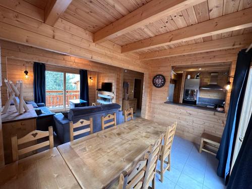 een keuken en eetkamer met een houten tafel en stoelen bij Oreeduloup Chalet Japp'loup 10/12 Pers. in Le Dévoluy