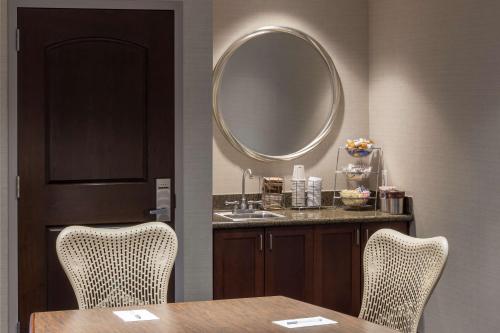 uma sala de jantar com uma mesa e um espelho em Hampton Inn & Suites Oklahoma City-Bricktown em Oklahoma City