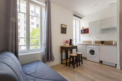a living room with a kitchen and a washing machine at Le George Gouy-Joli studio- Debourg Gerland in Lyon