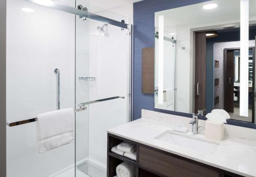 a bathroom with a sink and a shower with a mirror at Hilton Garden Inn Madison Downtown, WI in Madison