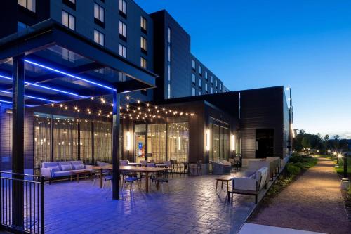 a building with a patio with tables and chairs at Hilton Garden Inn Madison Downtown, WI in Madison
