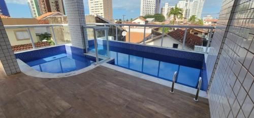 a balcony with a swimming pool on top of a building at Lindo apto piscina liberada e próximo à praia QX01H in Solemar