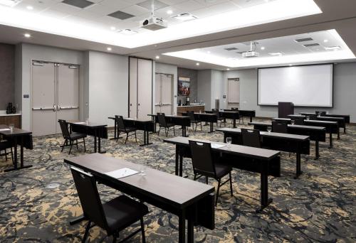 a classroom with tables and chairs and a projection screen at Hilton Garden Inn Madison Downtown, WI in Madison