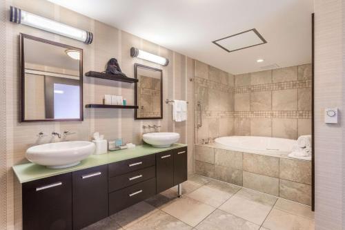 a bathroom with two sinks and a bath tub at Hampton Inn & Suites Madison Downtown in Madison