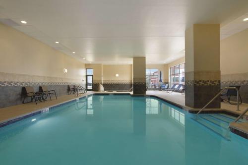 a large swimming pool with blue water in a building at Hilton Garden Inn Oklahoma City/Bricktown in Oklahoma City