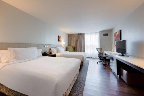 a hotel room with two beds and a television at Hilton Garden Inn North Houston Spring in Spring