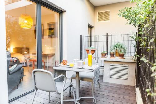 a patio with a table and chairs on a balcony at Studio avec Garage Neuf Gare Perrache Lyon centre in Lyon