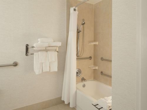 y baño con bañera, ducha y toallas. en Hilton Garden Inn Austin Downtown-Convention Center, en Austin