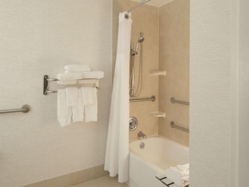 a bathroom with a tub and a shower with towels at Hilton Garden Inn Austin Downtown-Convention Center in Austin