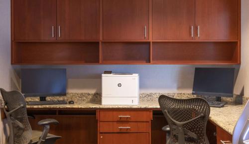 an office desk with two monitors and two chairs at Hilton Garden Inn BWI Airport in Linthicum Heights