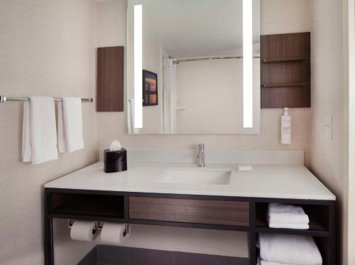 La salle de bains est pourvue d'un lavabo et d'un miroir. dans l'établissement Hilton Garden Inn Kent Island, à Grasonville