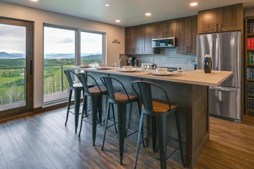 a kitchen with a large island with bar stools at Steamboat Springs Apt with Views, 15 Mi to Skiing! in Steamboat Springs
