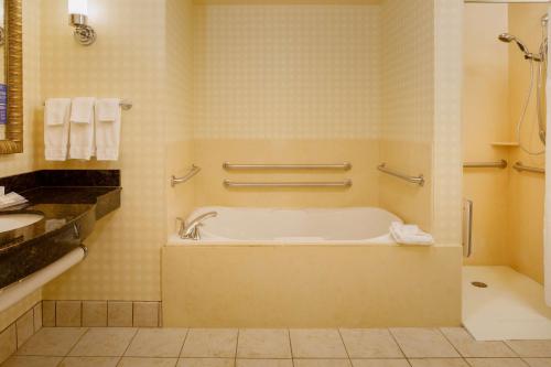 La salle de bains est pourvue d'une baignoire et d'un lavabo. dans l'établissement Hilton Garden Inn Cincinnati Blue Ash, à Blue Ash