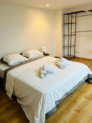 1 dormitorio con 1 cama blanca grande y toallas. en Appartement individuel situé à Créteil proche Henri Mondor, en Créteil