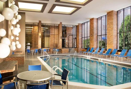 uma piscina com cadeiras e uma mesa e mesas e cadeiras em Hilton Parsippany em Parsippany