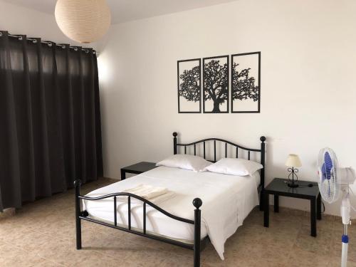 sypialnia z łóżkiem i 2 zdjęciami na ścianie w obiekcie Tarrafal Ecodécor Rooms w mieście Tarrafal