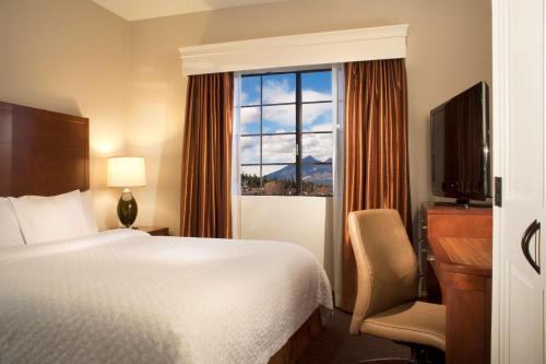 a hotel room with a bed and a window at Embassy Suites by Hilton Flagstaff in Flagstaff