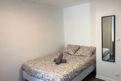 Un dormitorio con una cama con un osito de peluche. en Le Montesquieu-élégant studio -5 min Bellecour, en Lyon