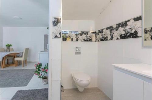 uma casa de banho branca com um WC e uma mesa em Kamer guesthouse em Bersebá