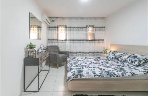 um quarto com uma cama e uma cadeira em Kamer guesthouse em Bersebá