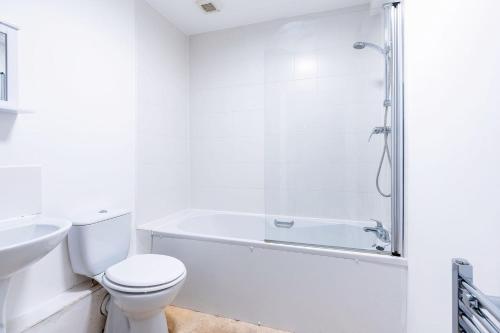 a white bathroom with a toilet and a shower at Newly Refurbished Stylish Central Apartment in Bradford