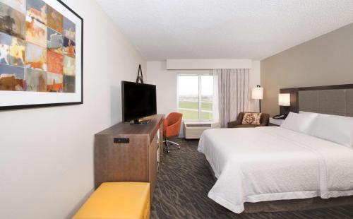Habitación de hotel con cama y TV en Hampton Inn & Suites N Ft Worth-Alliance Airport, en Roanoke