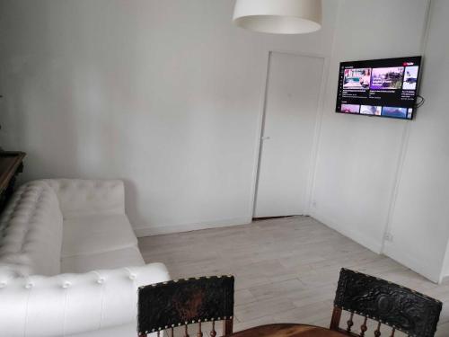 a living room with a white couch and two chairs at Appartement vintage in Vitry-sur-Seine
