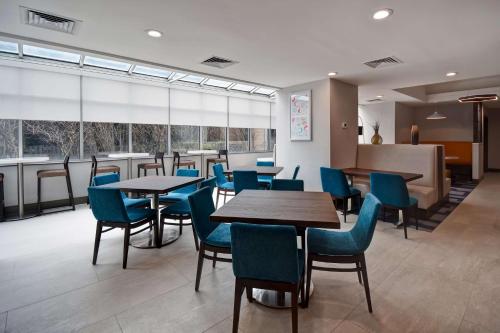 a dining room with tables and chairs and windows at Hampton Inn NY-JFK in Queens