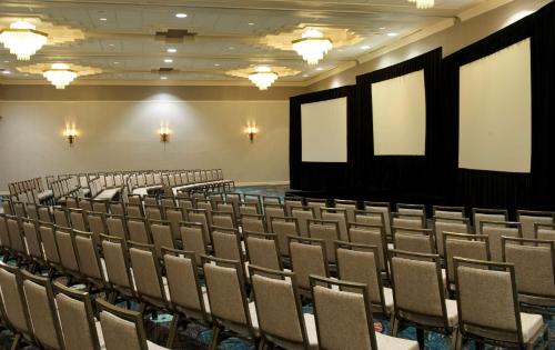an empty auditorium with rows of chairs and posters at Embassy Suites by Hilton Palm Beach Gardens PGA Boulevard in Palm Beach Gardens