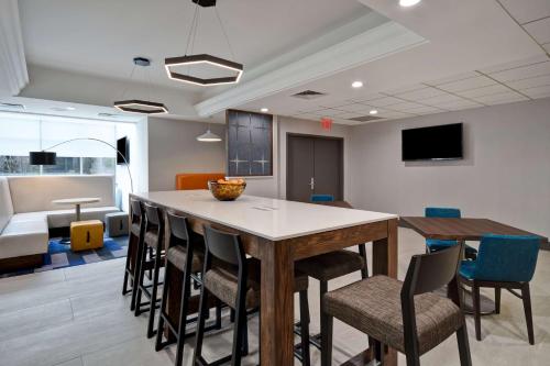 a kitchen and dining room with a table and chairs at Hampton Inn NY-JFK in Queens