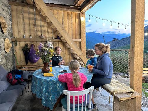 a group of people sitting at a table at Guesthouse Divo Hut in Ushguli