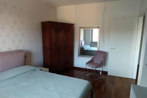 a bedroom with a bed and a mirror and a chair at Appartamento di Anna in La Spezia