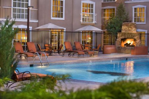 a hotel swimming pool with chairs and a fireplace at Hilton Santa Fe Historic Plaza in Santa Fe