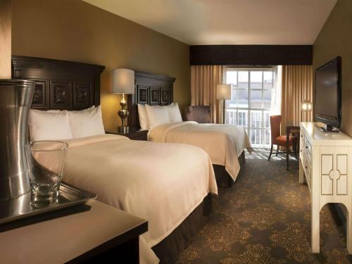 um quarto de hotel com duas camas e uma televisão em Hilton Santa Fe Historic Plaza em Santa Fé
