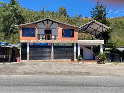 una casa con due porte garage e un balcone di Casa Montañita del RIO a Aratoca