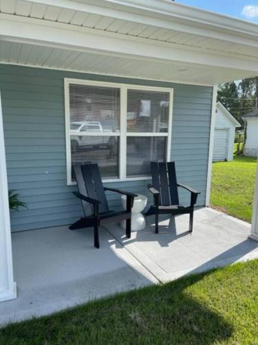 a patio with two chairs and a table in front of a house at Birdie Mae - 2 bedroom House in DT Hamilton in Hamilton