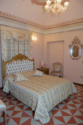 a bedroom with a large bed and a chandelier at Palazzo Tilli in Casoli