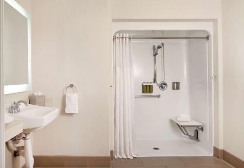 a white bathroom with a shower and a sink at Hilton Santa Cruz Scotts Valley in Santa Cruz