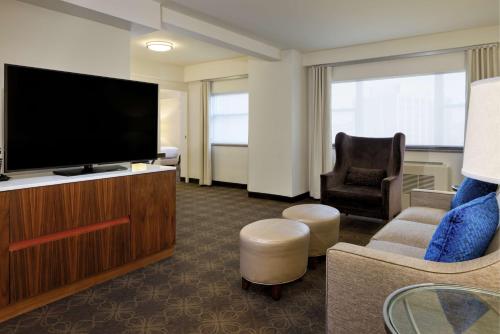 a hotel room with a flat screen tv and a chair at DoubleTree by Hilton Hotel & Suites Pittsburgh Downtown in Pittsburgh