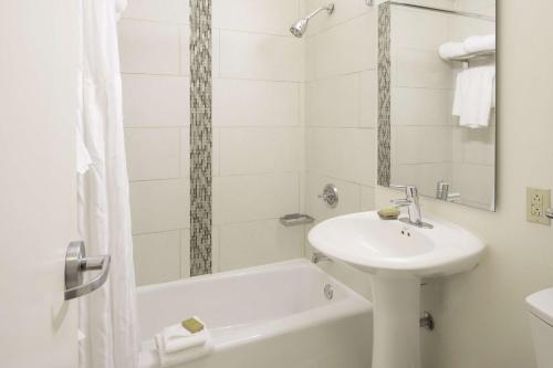 a white bathroom with a sink and a bath tub at DoubleTree by Hilton Hotel & Suites Pittsburgh Downtown in Pittsburgh